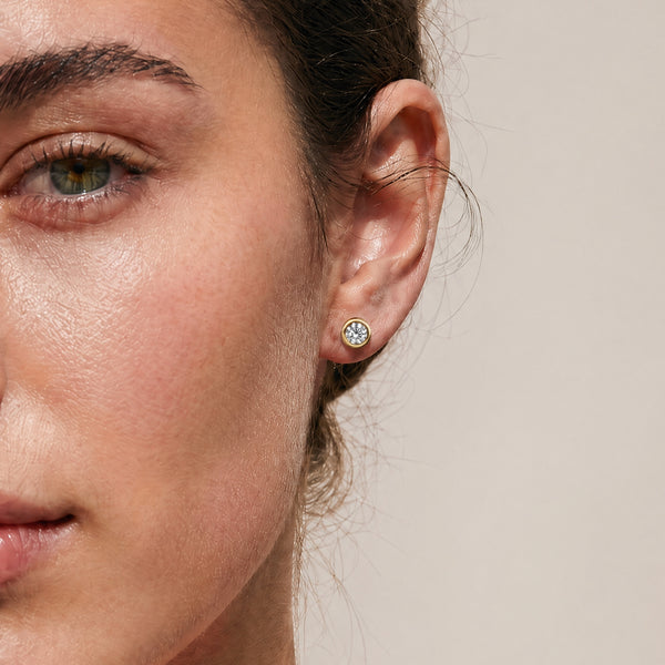 Yellow Gold 18k diamond bezel studs worn on model 