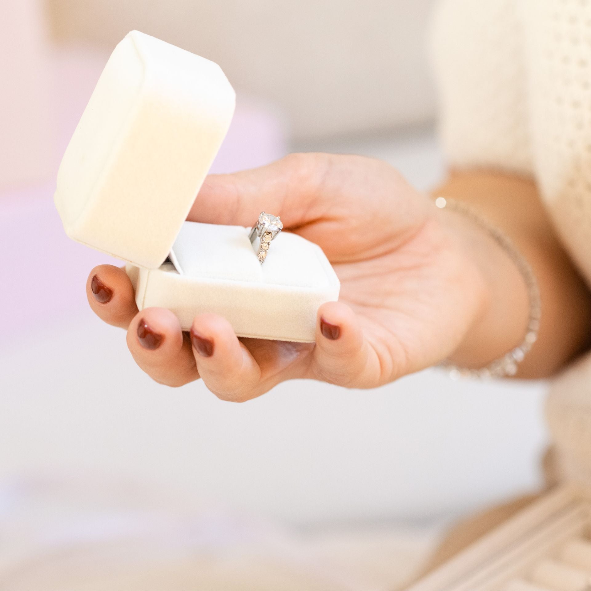 Hand holding jewelry box with engagement ring – traceable natural diamond with verified origin and provenance
