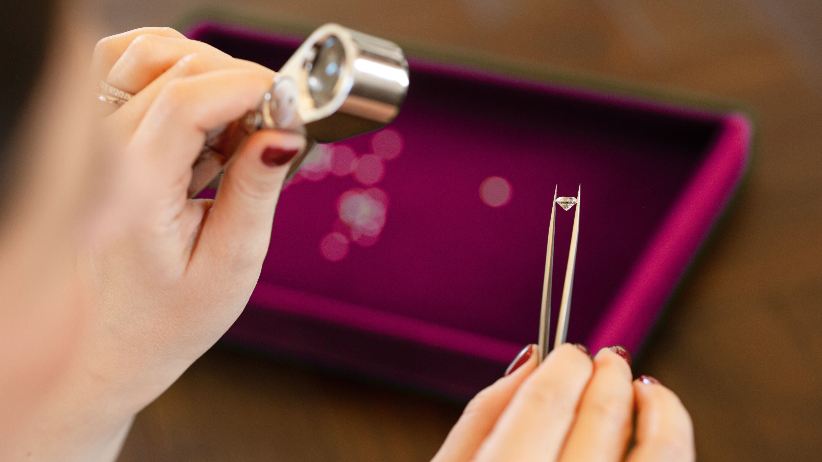 Founder Sarah inspecting a traceable natural diamond with loupe – bespoke diamond sourcing process