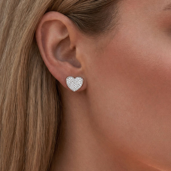Model wearing Esmeé pavé heart diamond earrings in 18k white gold with traceable natural diamonds.