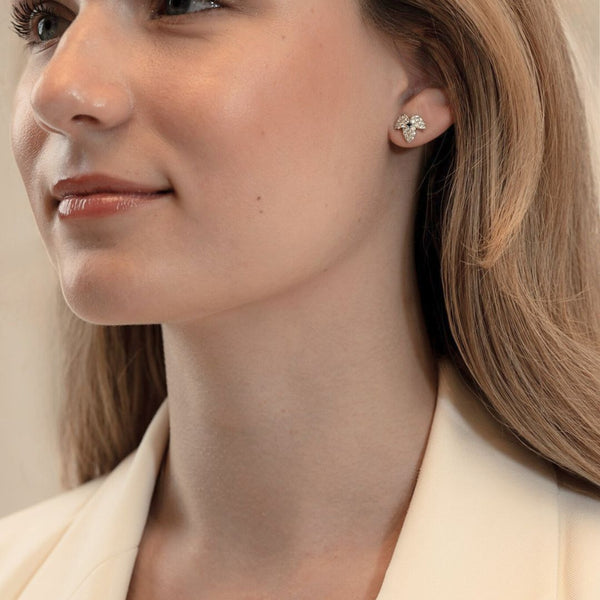 close-up of model wearing CAREDIAMONDS LUNIEVE earrings – radiant diamonds paired with vivid blue sapphires for a modern, elegant look.