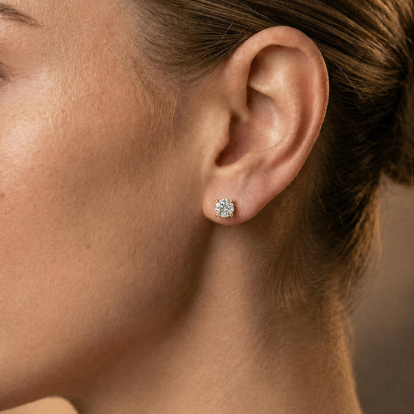 Classic diamond studs 18k yellow gold on ear of model