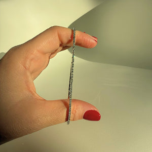 FELXIA flexible diamond tennis bracelet held between fingers, highlighting its ultra-slim, innovative clasp-free design.